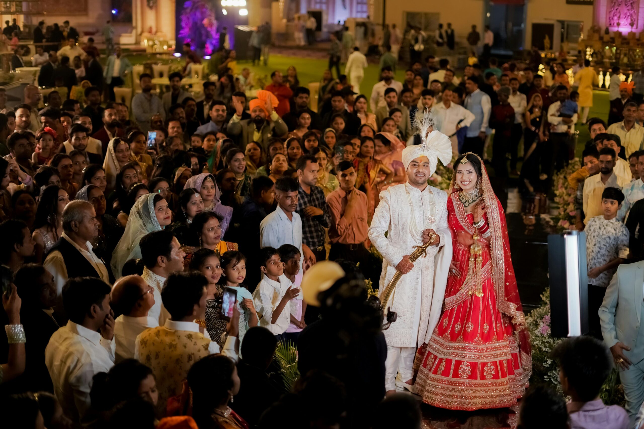 Vibrant Indian wedding ceremony with a joyful bride and groom surrounded by guests.