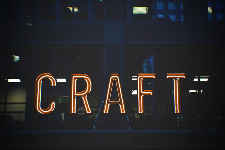 Illuminated neon sign with the word 'CRAFT' glowing against a building backdrop.